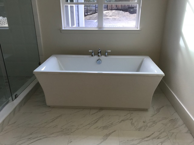 A Bathtub In White Color With Three Cock Tap